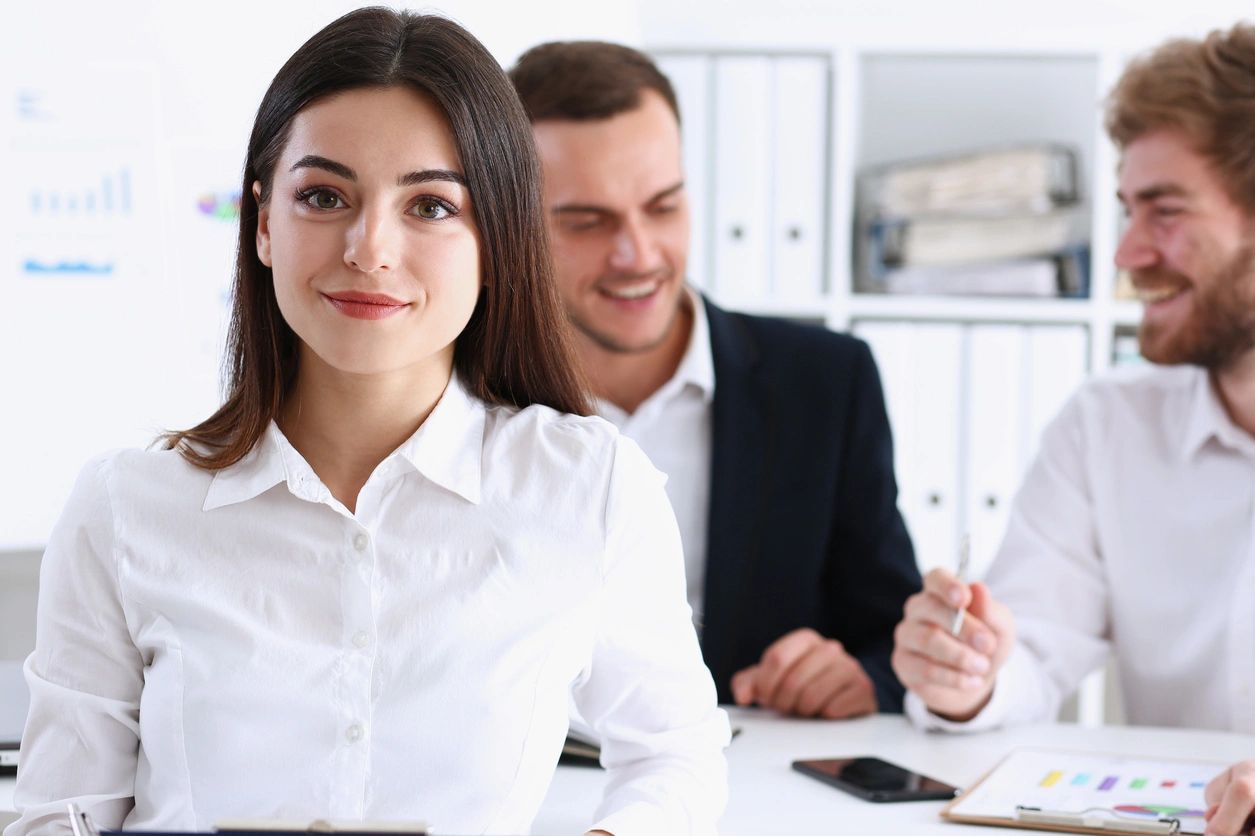 Smiling woman in office with two colleagues
