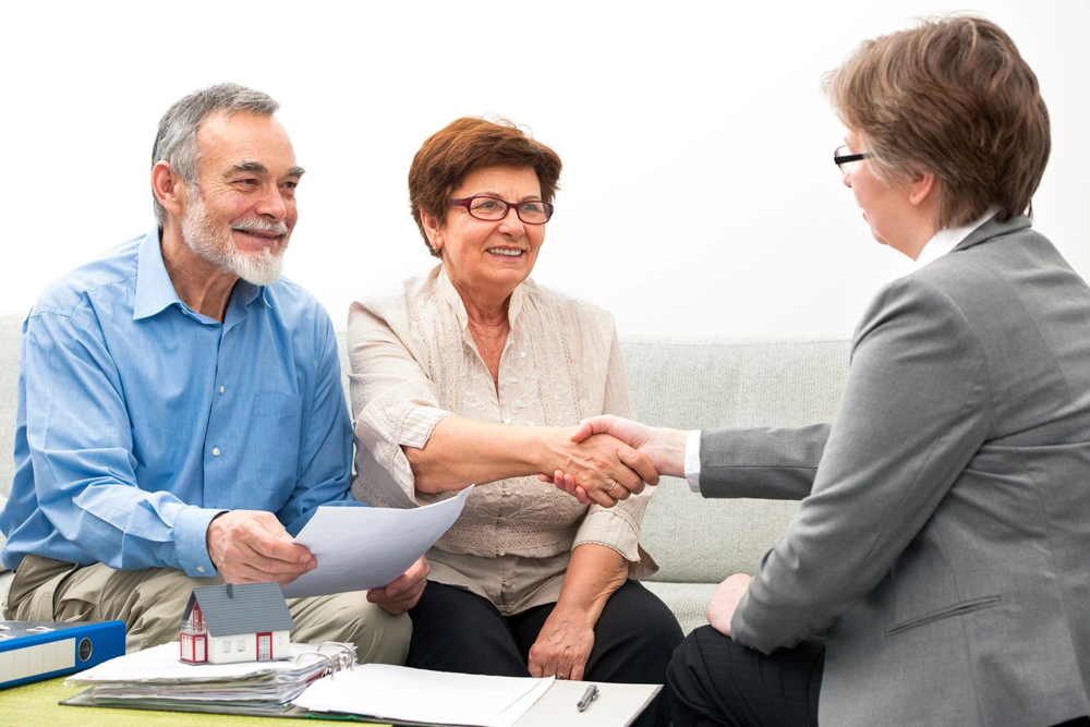 Senior couple shaking hands with financial advisor