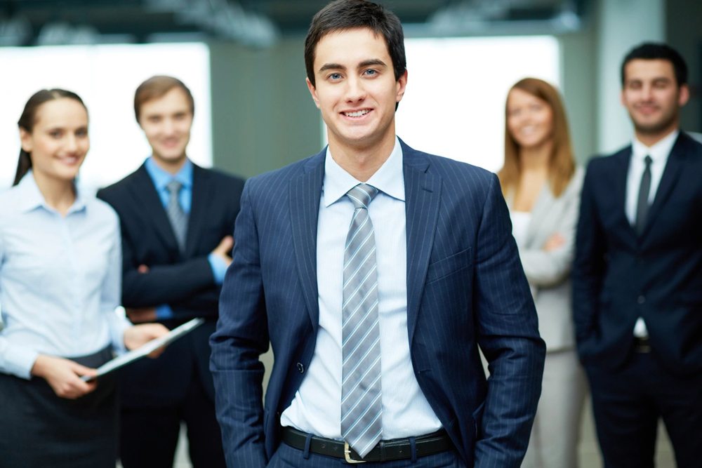 Smiling businessman standing with professional team
